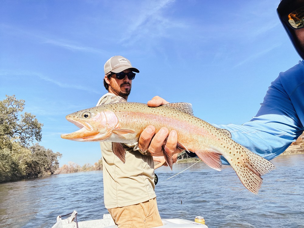 Traditional shot of guide holding clients fish